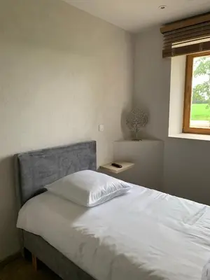 a bedroom with a white bed and a window at B&B elzartwinning in Hasselt