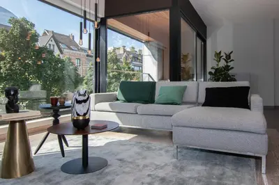 a living room with a couch and a table at Boulevard Botanie city apartment with parking in Hasselt