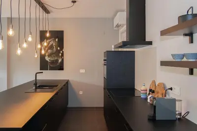a kitchen with black countertops and a black counter top at Boulevard Botanie city apartment with parking in Hasselt