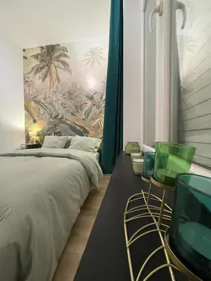 a bedroom with a bed and two green chairs at Patenier Hidden Garden 1bdr with garden in Liège