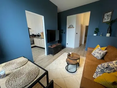 a living room with a couch and a tv at Patenier Hidden Garden 1bdr with garden in Liège