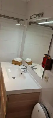 a bathroom with a white sink and a mirror at La cave de Nana in Liège