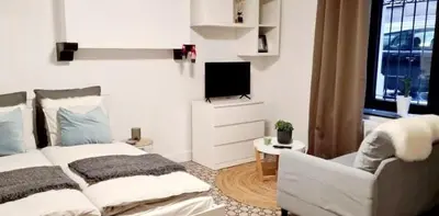 a living room with a bed and a television at La cave de Nana in Liège