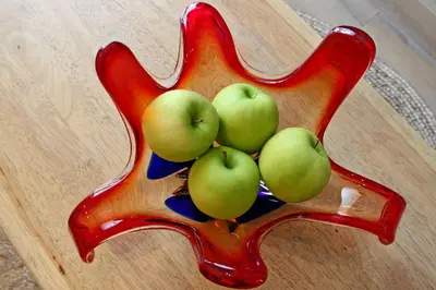 a bowl of green apples on a wooden table at Het Koerhuis in Kinrooi