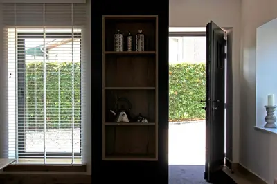 a room with a book shelf next to a door at Het Koerhuis in Kinrooi
