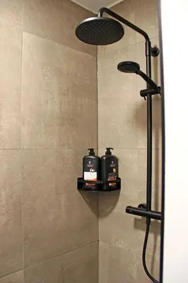 a shower with two soap dispensers in a bathroom at Het Koerhuis in Kinrooi
