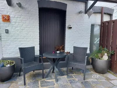 a patio with a table and chairs and a building at Le BELLEA in Verviers