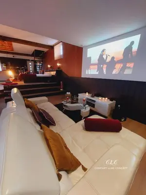 a living room with a white couch and a screen at Le BELLEA in Verviers