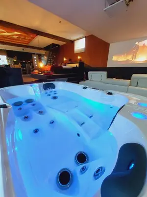 a jacuzzi tub in a room with a couch at Le BELLEA in Verviers