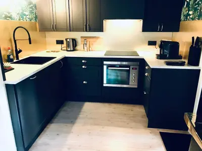 a kitchen with blue cabinets and a microwave at Chalet Maurice in Zutendaal