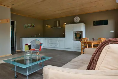 a living room with a couch and a table at Le gîte de l'écurie des Saules in Plombières