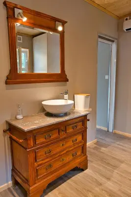 a bathroom with a sink and a mirror on a dresser at Le gîte de l'écurie des Saules in Plombières