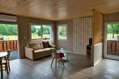 a living room with a couch and a table at Le gîte de l'écurie des Saules in Plombières