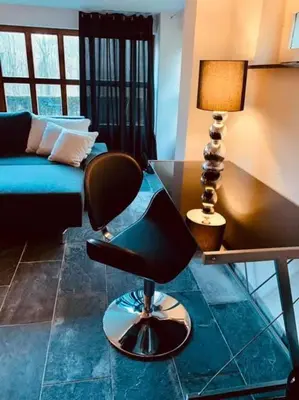 a living room with a chair and a table at Grey House in Olne