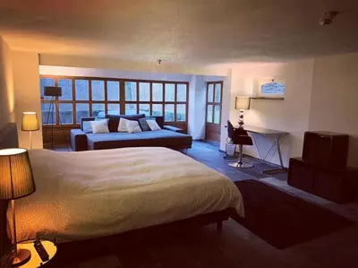 a bedroom with a bed and a television in it at Grey House in Olne
