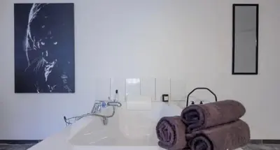 a bathroom with a tub with towels on it at Grey House in Olne