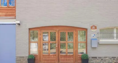 a wooden door on the side of a building at Grey House in Olne
