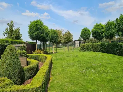 a garden with trimmed hedges and a fence at Alken Farm Stay with Terrace in Alken