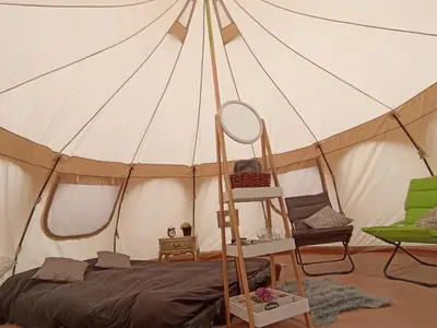 a bedroom with a tent with a bed and a mirror at Natuur-like Glamping in Bosland in Pelt