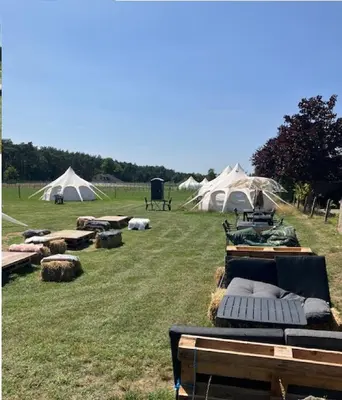 a group of tents in a field with hay at Natuur-like Glamping in Bosland in Pelt