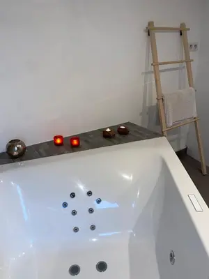 a white bath tub with candles in a bathroom at L'Entre-Temps in Xhendelesse