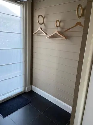 a corner of a room with hangers and a window at Chalet Eau Vive Meinekom in Maaseik