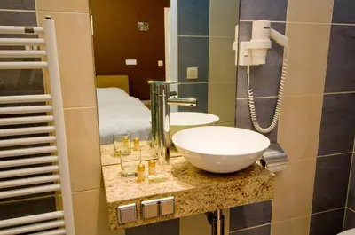 a bathroom with a bowl sink and a bed at De Zilveren Helm in Halen
