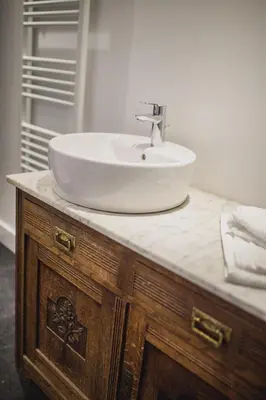 a sink on top of a wooden vanity in a bathroom at Le Mayou in Mortroux