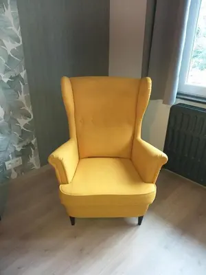 a yellow chair in a room with a window at La Maison de Sidonie in Jalhay