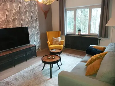 a living room with a couch and a flat screen tv at La Maison de Sidonie in Jalhay