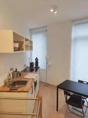 a kitchen with a sink and a table in a room at Studio Citadelle - Chambres avec salle de bain indépendantes et cuisine partagée in Liège