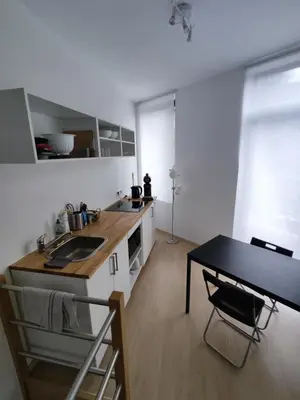 a kitchen with a sink and a table with a desk at Studio Citadelle - Chambres avec salle de bain indépendantes et cuisine partagée in Liège