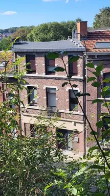 a brick building with a solarium on top of it at Studio Citadelle - Chambres avec salle de bain indépendantes et cuisine partagée in Liège