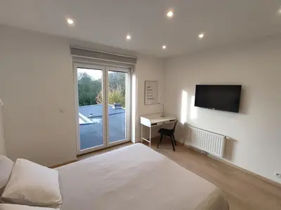 a bedroom with a bed and a desk and a television at Studio Citadelle - Chambres avec salle de bain indépendantes et cuisine partagée in Liège