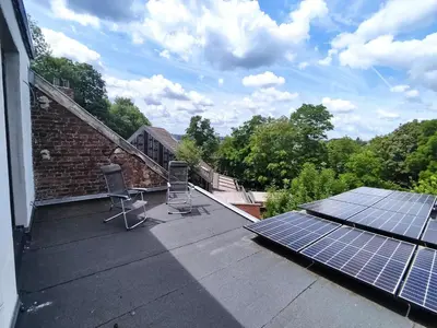 a roof with two chairs and solar panels on it at Studio Citadelle - Chambres avec salle de bain indépendantes et cuisine partagée in Liège