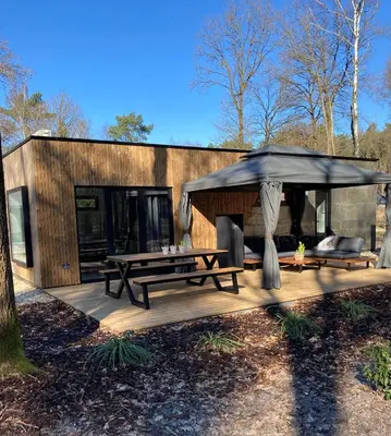 a wooden deck with a picnic table and an umbrella at Sweet Valley Julia in Zutendaal