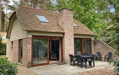 a small brick house with a table and chairs at Sonnevijver Vijverdorp-Waterl in Bovenwezet