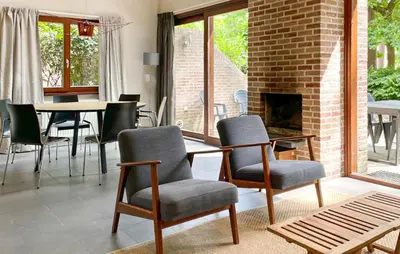 a living room with chairs and a table and a fireplace at Sonnevijver Vijverdorp-Waterl in Bovenwezet