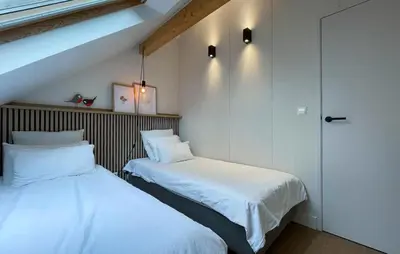 two beds sitting next to each other in a room at Sonnevijver Vijverdorp-Waterl in Bovenwezet
