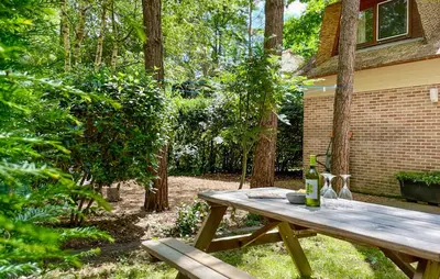 a wooden picnic table with two bottles of wine on it at Sonnevijver Vijverdorp-Waterl in Bovenwezet