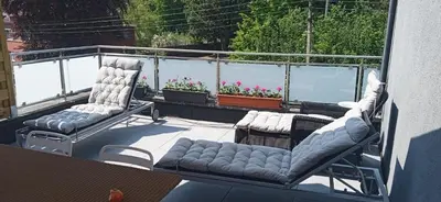 two chairs and a couch on a balcony at liège 4420 rue jean Jaurès 45 grande maison joyeuse avec terrasse 30m2 pour 8 personnes maximum in Saint-Nicolas