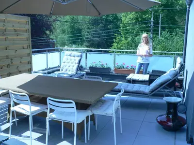 a little girl standing on a patio with a table and chairs at liège 4420 rue jean Jaurès 45 grande maison joyeuse avec terrasse 30m2 pour 8 personnes maximum in Saint-Nicolas