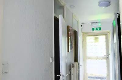 a hallway with a door with a exit sign on it at Calme et verdure 9 in La Calamine