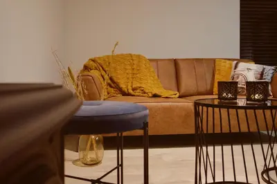 a living room with a couch and a blue stool at Sweet Valley Madeleine in Zutendaal