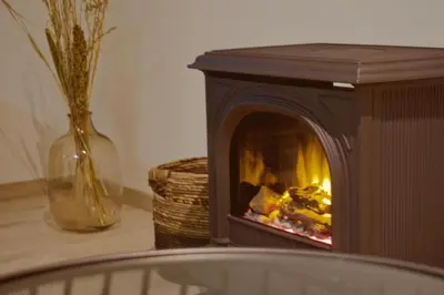 a fireplace sitting on a table next to a vase at Sweet Valley Madeleine in Zutendaal