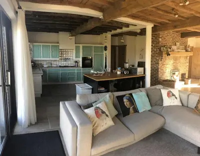 a living room with a couch and a kitchen at 14P 5B Villa de Poothoeve with Sauna and beautiful garden in Bilzen