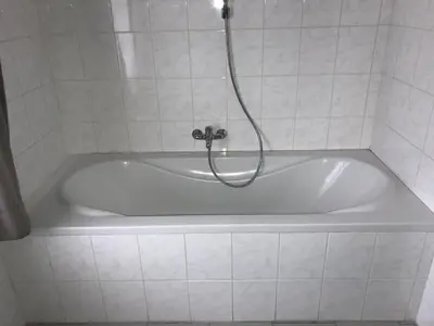 a white bath tub with a shower in a bathroom at 8P 3B Cozy vacation home for 8 persons in Heers in Heers