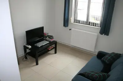 a living room with a blue couch and a tv at Vakantiehuis Martien in Peer