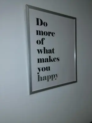 a framed picture on a wall with the words do more of what makes you happy at Vakantiehuis Martien in Peer