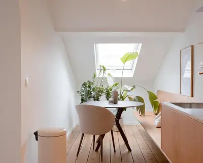a kitchen with a table and chairs in a room at La Maison de Chestret in Liège